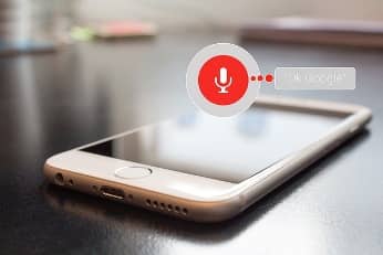 Photo of iPhone being used for voice search to find a business.